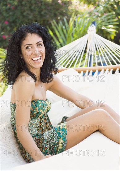 Mixed race woman sitting in hammock