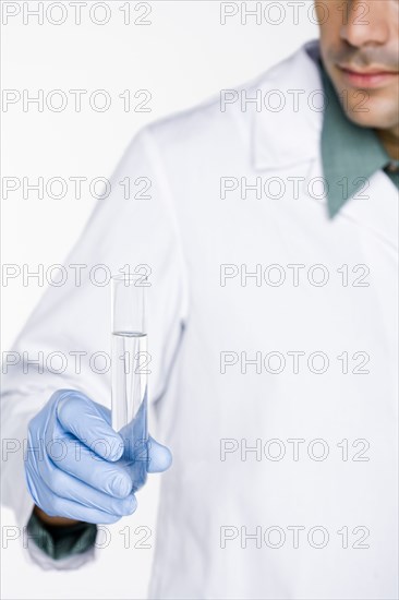 Hispanic scientist holding test tube full of water