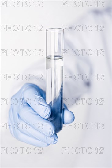 Hispanic scientist holding test tube full of water