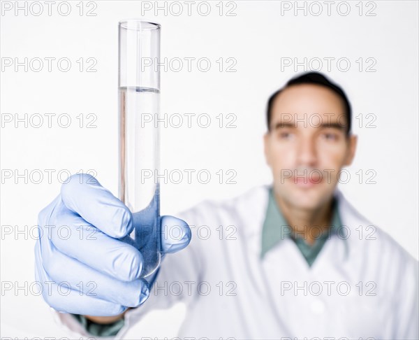 Hispanic scientist holding test tube full of water