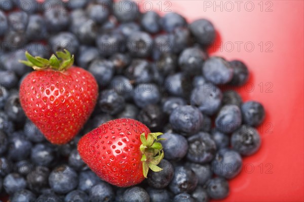 Strawberries on pile of blueberries