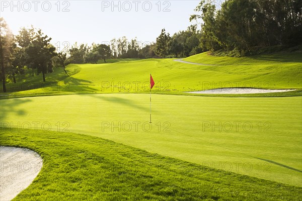 Flag on golf course surrounded by sand traps