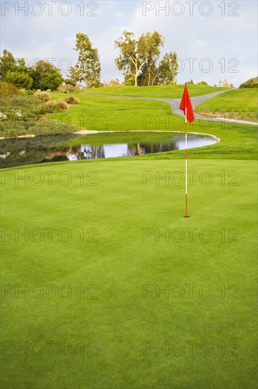 Flag on golf course next to pond