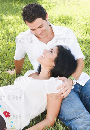Pregnant woman laying in husband's lap