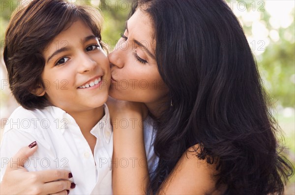 Mixed race mother kissing son