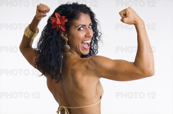 Mixed race woman body builder flexing muscles