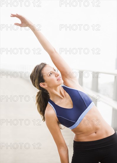 Hispanic woman stretching before exercise