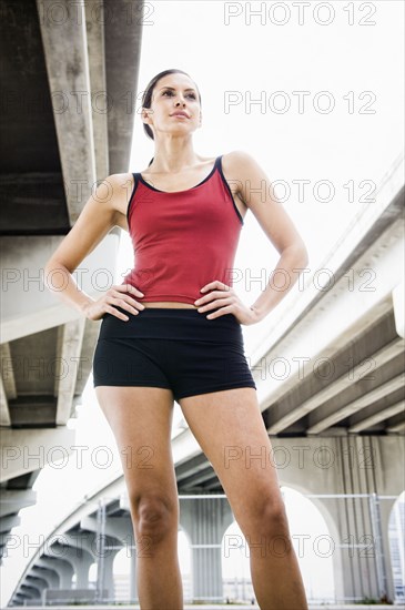 Hispanic woman in sportswear standing in urban area