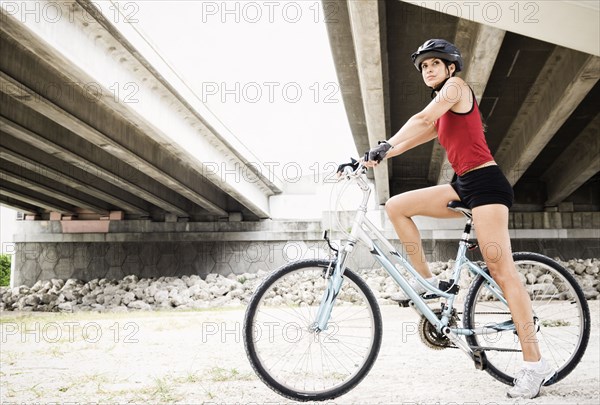 Hispanic woman riding bicycle in urban area