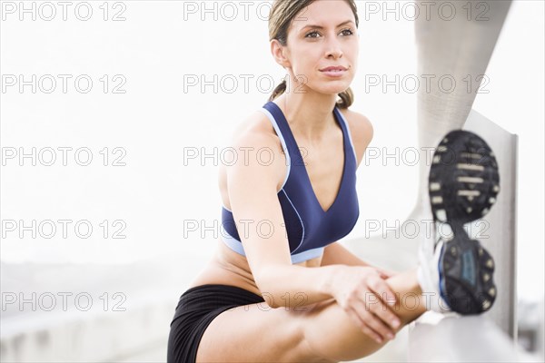 Hispanic woman stretching before exercise