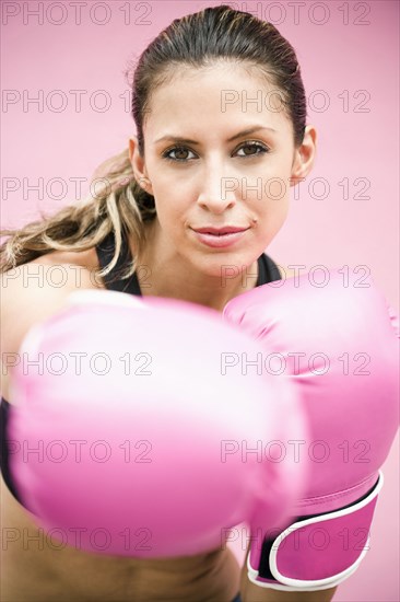 Hispanic woman in boxing gloves punching