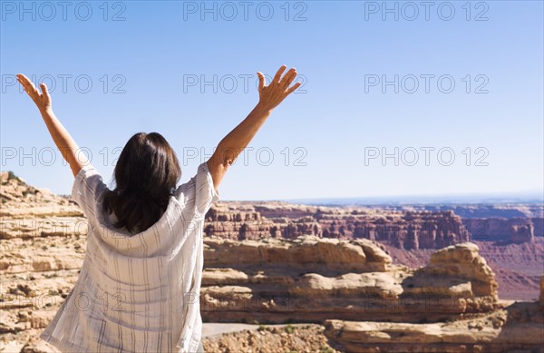 Hispanic woman cheering near canyon