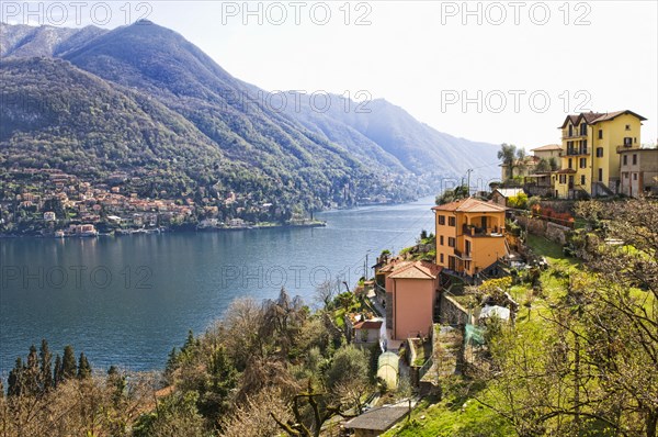 Houses on hillside next to remote lake