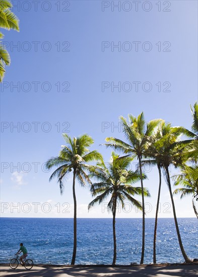 Caucasian woman bike riding near tropical ocean