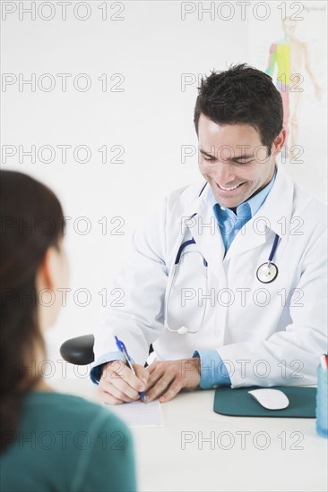 Doctor sitting at desk with patient