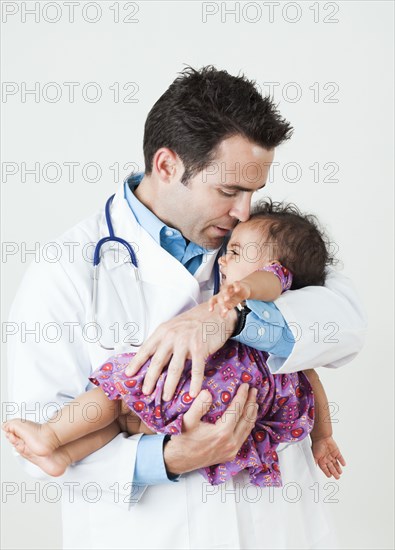 Doctor comforting baby girl