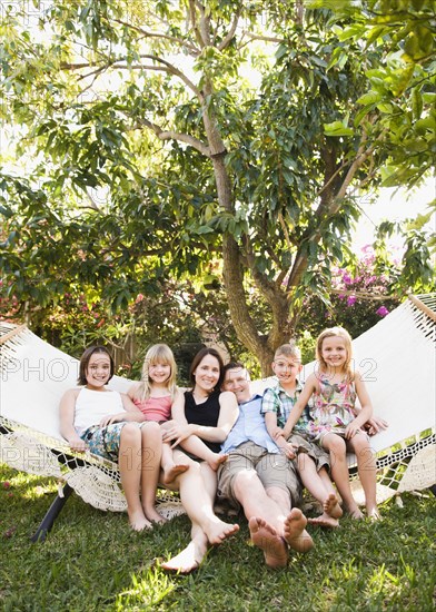 Caucasian children sitting in hammock