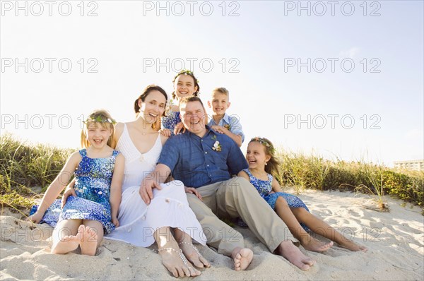 Caucasian family sitting together on beach