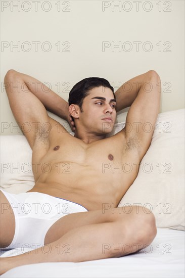 Hispanic man laying on bed