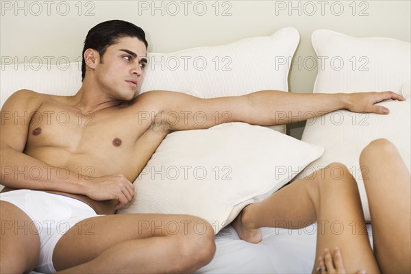 Hispanic couple laying on bed