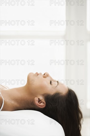 Hispanic woman laying on bed