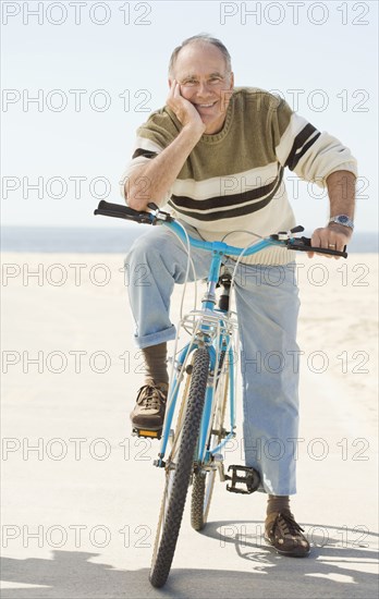 Caucasian older man sitting on bicycle