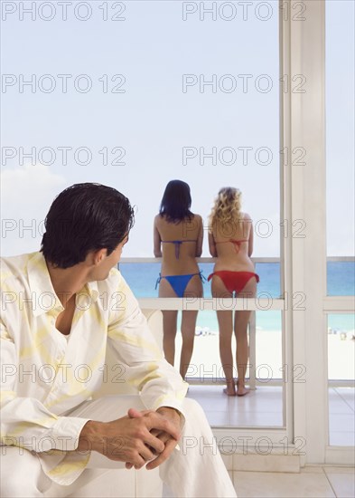 Caucasian man admiring women in bikinis