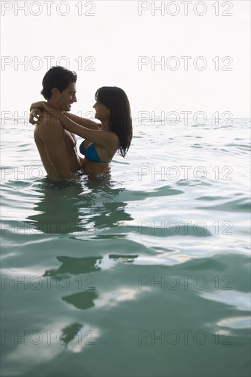 Smiling couple hugging in water