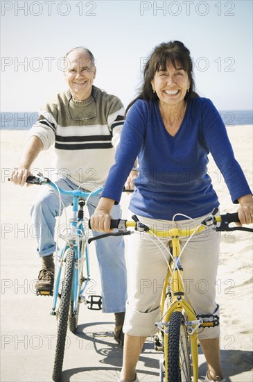 Couple riding bicycles on beach