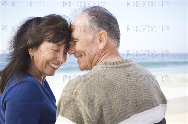 Smiling couple hugging on beach