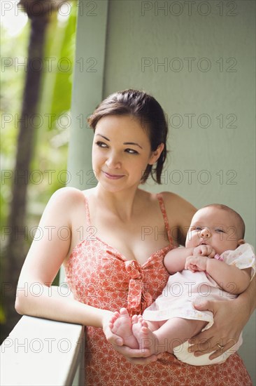 Mixed race mother cradling baby