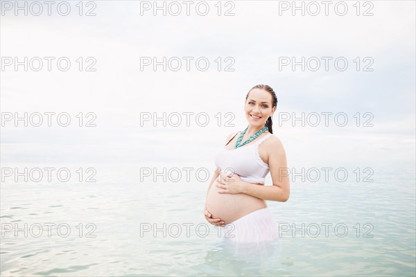 Pregnant Caucasian woman standing in water