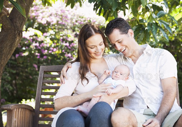 Caucasian couple holding baby outdoors