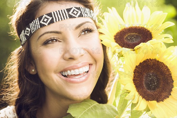 Hispanic woman holding sunflowers