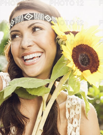 Hispanic woman holding sunflowers