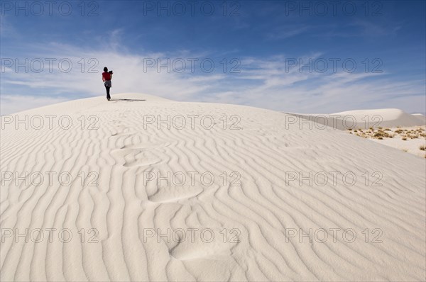 Man climbing sand dune in desert