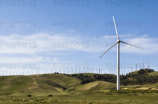 Wind turbines lining hilltop in rolling landscape