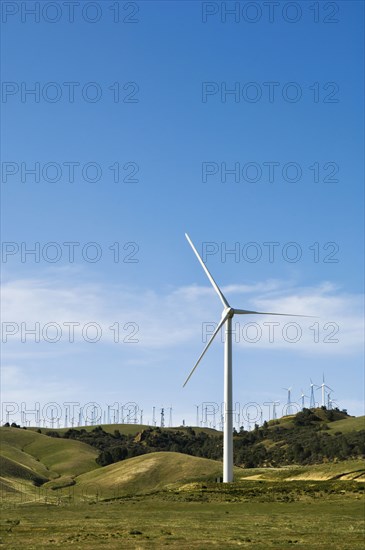 Wind turbines lining hilltop in rolling landscape