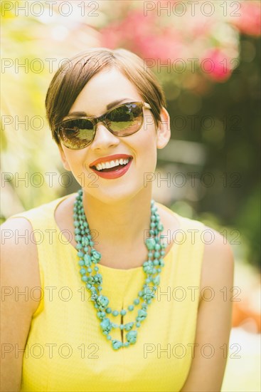 Caucasian woman wearing sunglasses and necklace outdoors