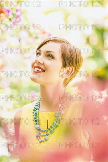 Caucasian woman admiring flowers in garden