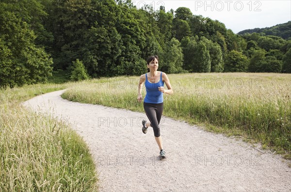 Mixed race woman running on path