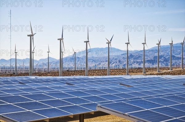 Wind turbines and solar panels in remote landscape