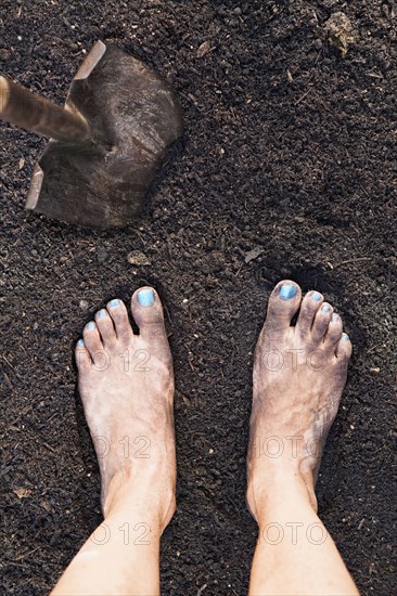 Mixed race woman barefoot in dirt