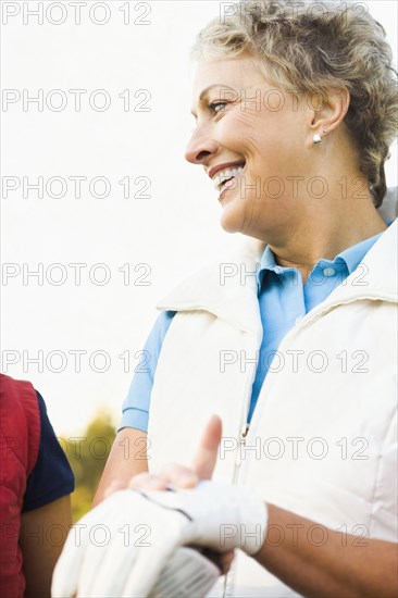 Caucasian woman wearing gloves on golf course