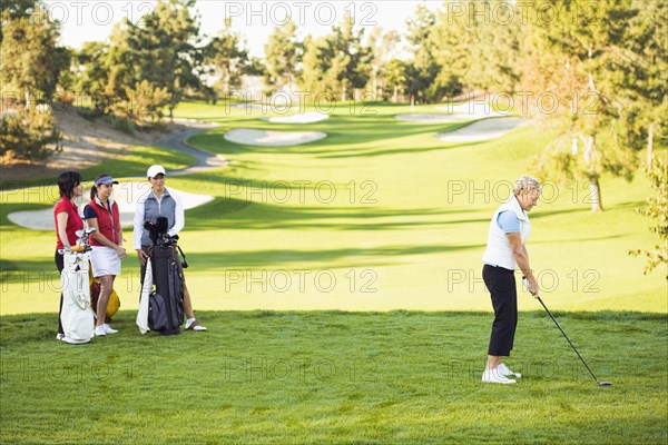 Women playing golf on golf course