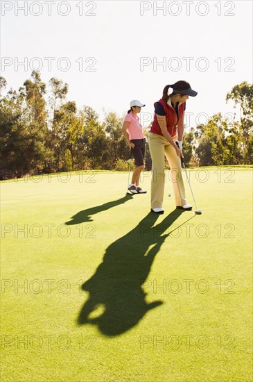 Women playing golf on golf course