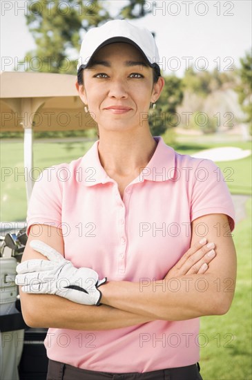 Mixed race woman smiling on golf course