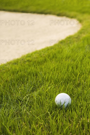 Close up of golf ball near sand trap on golf course