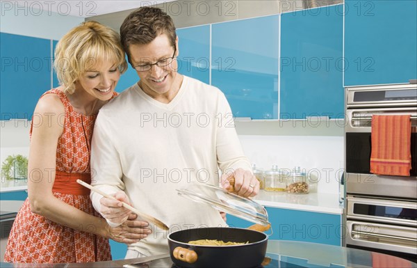 Caucasian couple cooking in kitchen