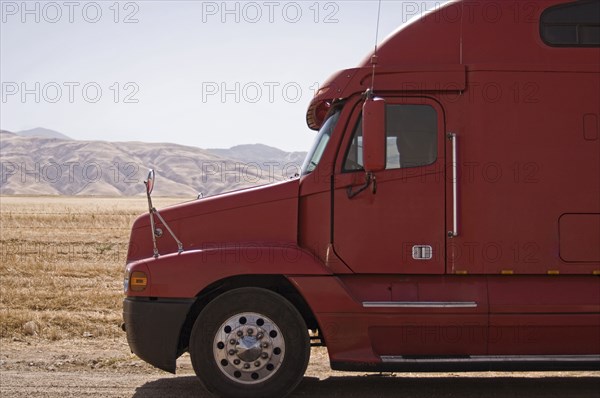 Red semi-truck against mountains